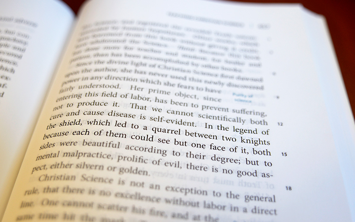 Image description: Staff photo of page 457 of Science and Health. The sentence referring to "the legend of the shield" is in focus near the middle of the photo.