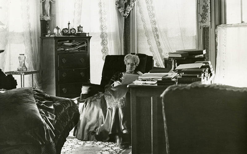 Mary Baker Eddy assise à son bureau, à Pleasant View, début des années 1900.