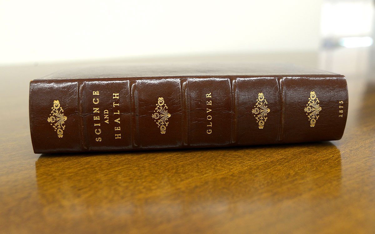 2022-11d_-_1st_Edition_S&H_-_spine_02-crop Leather bound Science and Health laid on a table