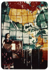 Vintage color photo of a woman standing in the Mapparium.